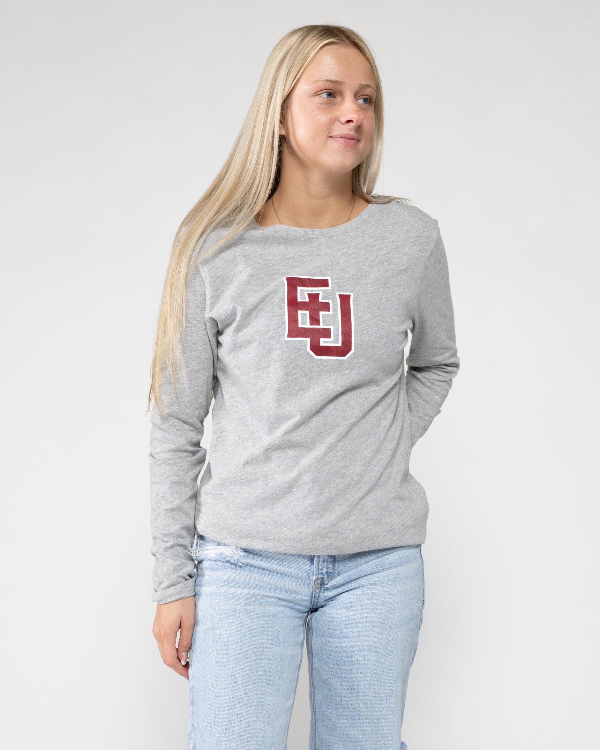 Woman wearing a gray long-sleeve shirt with a logo on a white background