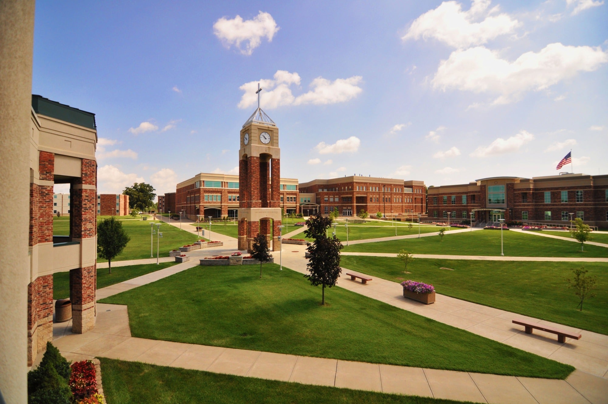 Campus with a clock tower under a blue sky with clouds